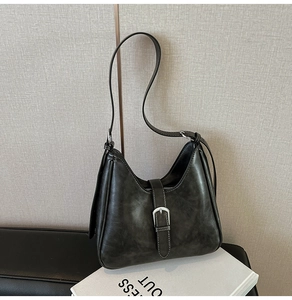 Détail du sac à bandoulière vintage avec coutures contrastées et boucle décorative