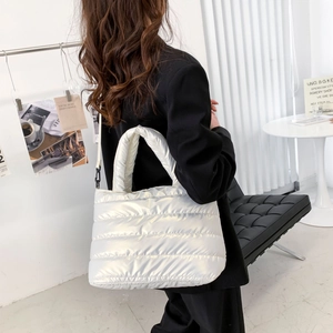 Lifestyle-Foto einer weißen gesteppten Puffer-Tasche mit abnehmbarem Schultergurt