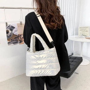 Rückansicht der weißen gesteppten Puffer-Tasche mit breitem Nylongurt am Modell