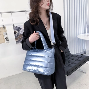 Detailansicht der hellblauen metallischen gesteppten Puffer-Tasche an einem Model