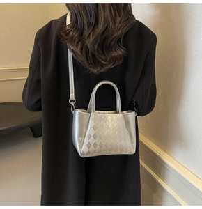 Silberne Stepp-Beuteltasche mit Metallic-Finish, präsentiert an einem schwarzen Mantel