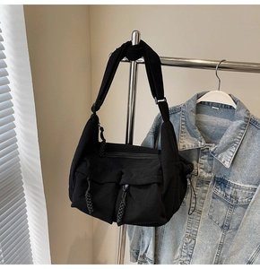 Detail der schwarzen Cord-Schultertasche mit Klappentaschen und Reißverschluss aus Kordel