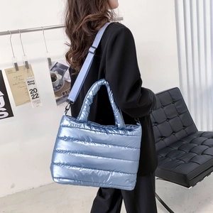 Detailansicht der hellblauen gesteppten Puffer-Tragetasche mit glänzendem Metallic-Finish
