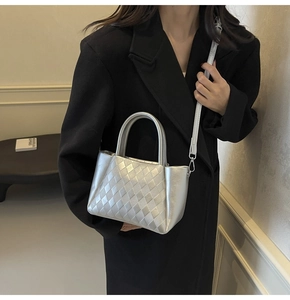 Detailansicht der silbernen Handtasche mit Webstruktur und metallischem Glanz