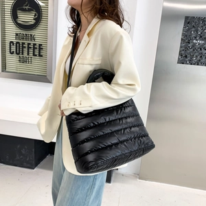 Modische schwarze gesteppte Puffer-Tasche an einem Model in minimalistischem Design