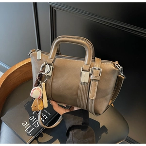 Vue détaillée d'un sac Boston en cuir marron avec breloque vintage thème baseball