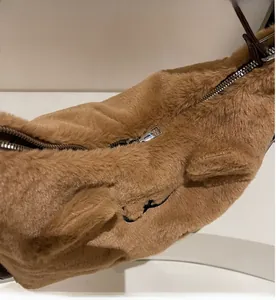 Close-up of smooth metal zipper and plush faux fur texture on the coffee brown bag