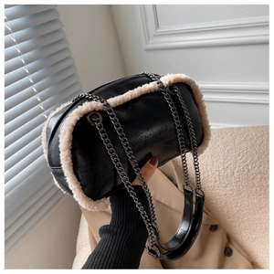Detail of crossbody bag with faux fur trim, silver chain straps and oily leather texture
