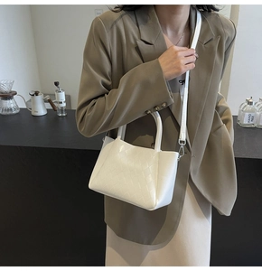 Detail der weißen Stepp-Eimertasche mit Webstruktur und verstellbarem Schultergurt