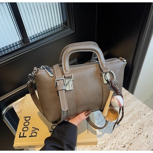 Gros plan d'un sac à main en cuir mat marron avec breloques créatives thème baseball