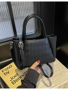 Fashionable black woven tote bag with round handles and detachable crossbody strap