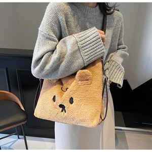 Detail der braunen Plüschtasche mit Bärenstickerei und verstellbarem Lederriemen