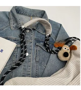 Corduroy shoulder strap detail with black and white braided rope and plush dog charm