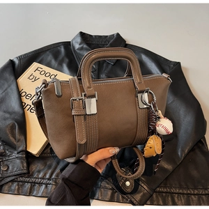 Détail du sac docteur en similicuir mat marron foncé avec breloque de baseball