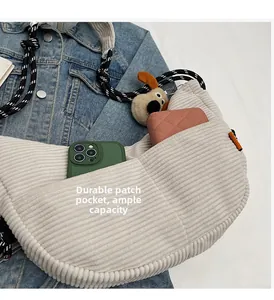 Detail of corduroy crossbody bag featuring a large front pocket with phone and wallet