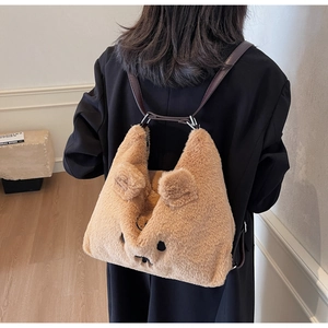 Detailansicht eines khakifarbenen Plüschrucksacks mit 3D-Ohren und Bestickung am Modell