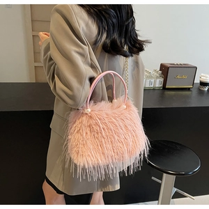 Detailed close-up of pink faux fur bucket bag with pearl handle and chain strap