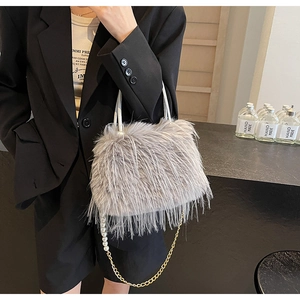 Detail of grey faux fur bucket bag with pearl chain and leather handle texture