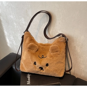 Detailed view of brown plush tote bag with bear embroidery and adjustable leather strap