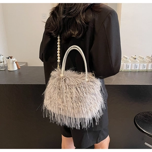 Detail of luxury gray faux fur bucket bag with pearl chain strap and elegant handle
