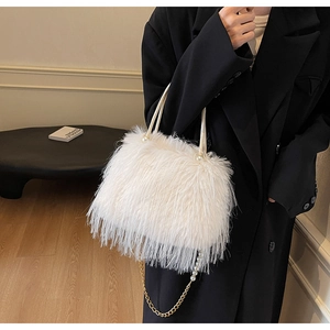 Detail of white faux fur handbag featuring pearl accents and gold metal chain strap