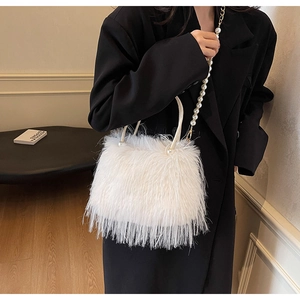 Detail of luxury white feather bucket bag featuring pearl straps and elegant handle