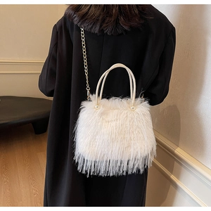 Detail view of plush faux fur bucket bag with pearl handle and gold chain strap