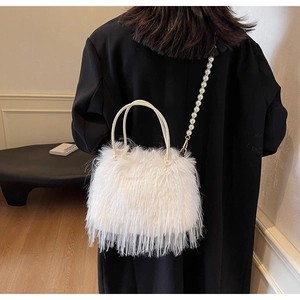 Close-up of fluffy white faux fur bucket bag with elegant pearl handle and strap