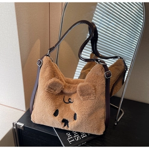 Detail einer braunen Plüschtasche in Bärenform mit weichem Kunstfell und süßer Stickerei