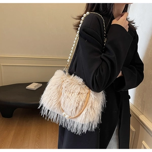 Close-up of fluffy white faux fur shoulder bag with elegant pearl chain and U-shaped handle
