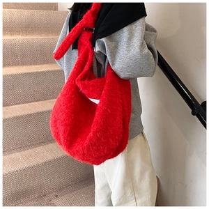 Gros plan d'un sac cabas en peluche rouge avec étiquette blanche et texture douce
