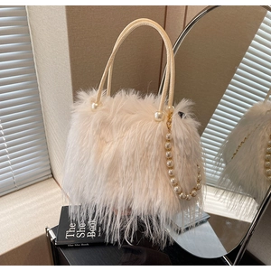 Close-up of plush faux fur bucket bag with pearl handle and elegant chain details