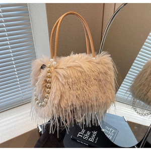 Detail of beige faux fur bucket bag with pearl chain and brown leather handles