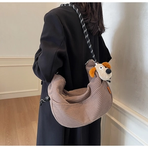 Brown corduroy hobo bag with braided strap and cute puppy pendant shown on model
