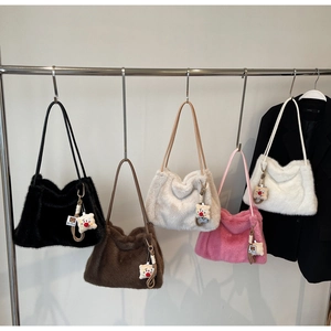 Dettaglio di borse tote in peluche in cinque colori con ciondolo a orso per l'inverno