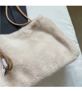 Dettaglio della texture in finta pelliccia beige e del materiale morbido della borsa