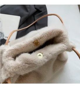 Dettaglio della borsa in ecopelliccia beige con chiusura magnetica dorata e fodera interna