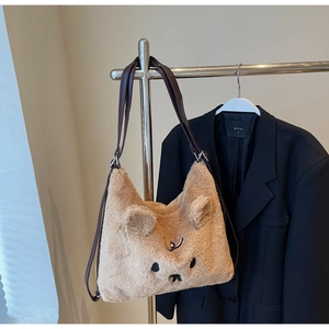 Nahaufnahme einer khakifarbenen Plüsch-Schultertasche mit Bärenohren und Stickerei