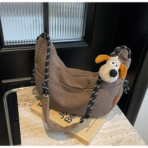 Detail of dark brown corduroy hobo bag with thick rope strap and plush toy charm