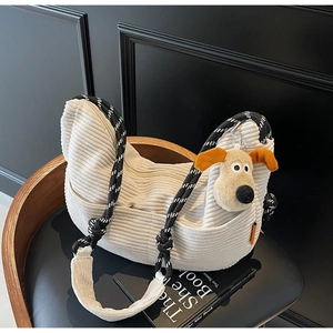 Close-up of beige corduroy dumpling bag with rope strap and plush puppy charm