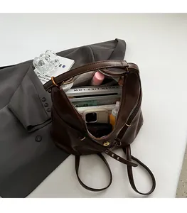 Top view of spacious interior of dark brown leather tote bag with gold zipper and gray lining