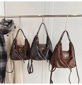 Detailed view of three hobo bags in dark brown, black and caramel with metallic logo