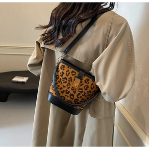 Detail der Leopard-Eimertasche mit Goldmagnetverschluss auf beigem Trenchcoat