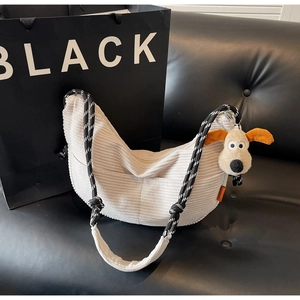 Detail of off-white corduroy crescent bag with woven strap and cute plush dog charm