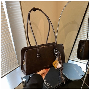 Primer plano de un bolso de hombro marrón vintage con un accesorio de guante de béisbol