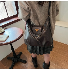 Close-up of retro dark brown large tote bag with metallic triangle logo and straps