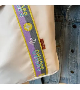 Detail of the woven colorful shoulder strap and fabric texture of the casual tote bag