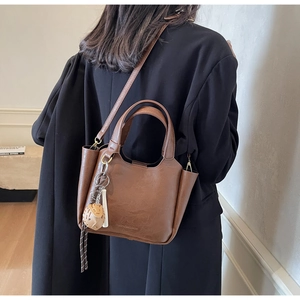 Vue détaillée d'un sac seau vintage en cuir marron foncé avec logo de marque embossé