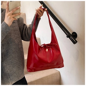 Mirror selfie showing the large glossy red patent leather tote bag with bow detail