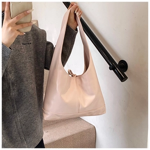 Mirror selfie showing a glossy pale pink patent leather tote bag with bow detail
